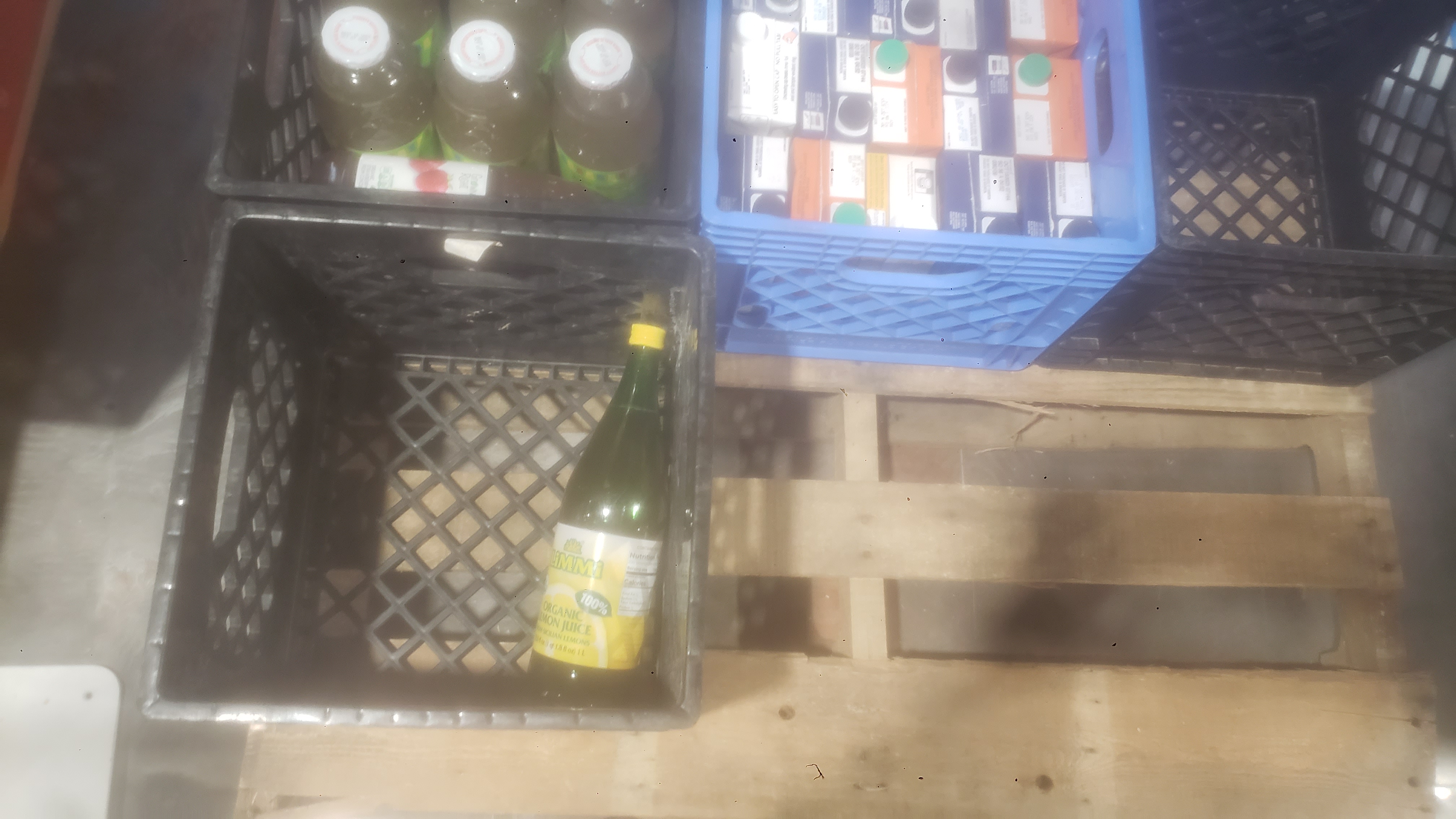Crates full of stock cartons and bottles of juice.